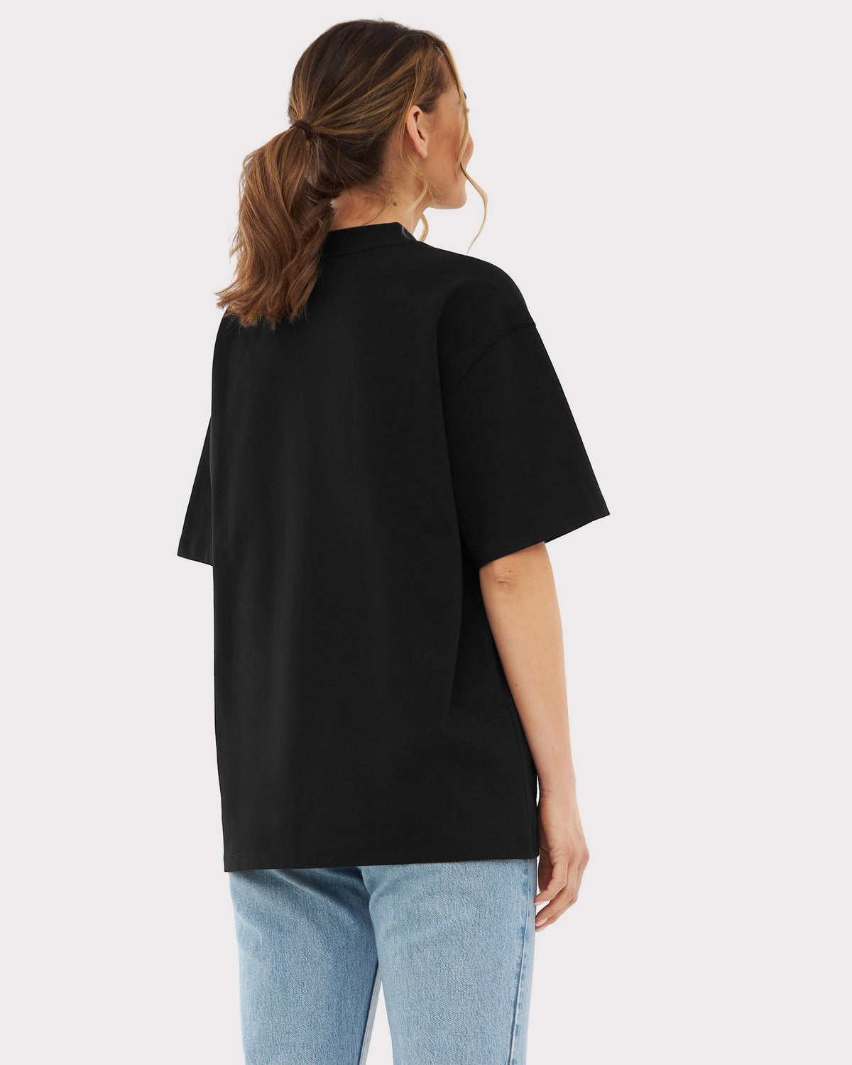 Frau von hinten in schwarzem, oversized T-Shirt 'Sammy' und blauen Jeans