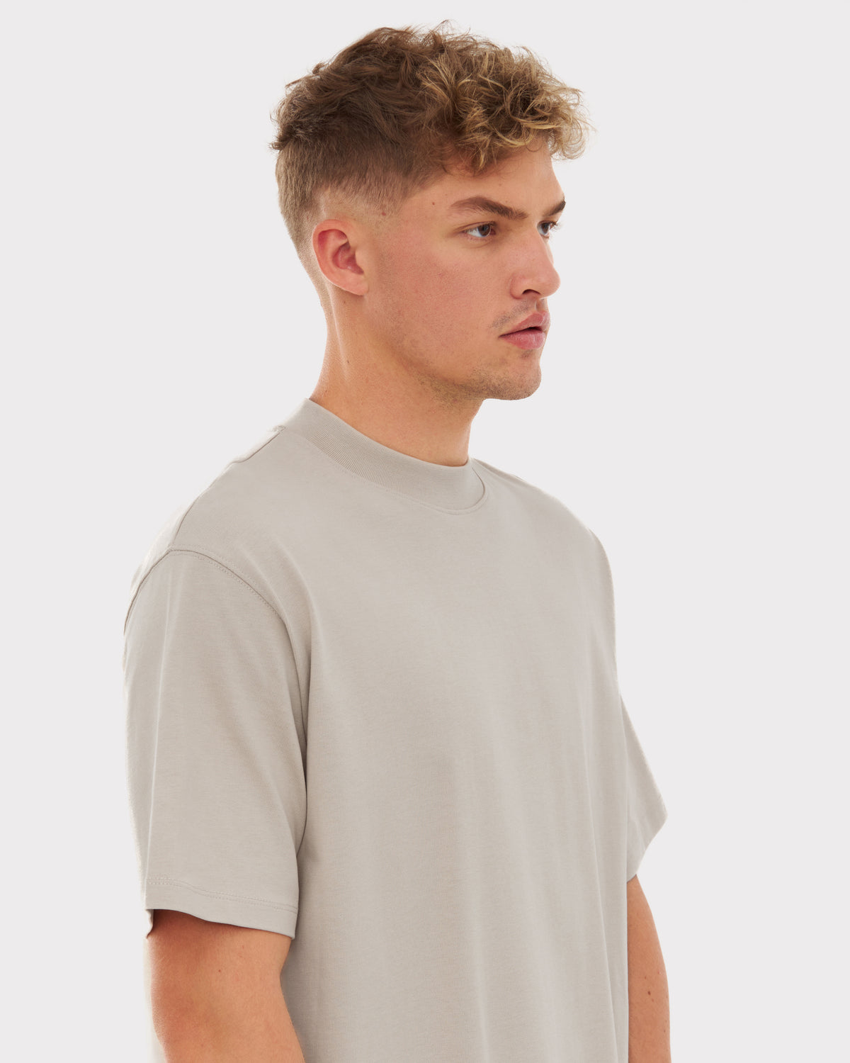 Mann mit kurzem lockigem Haar trägt beige T-Shirt 'Sammy' von Johnny Urban in moderner Passform