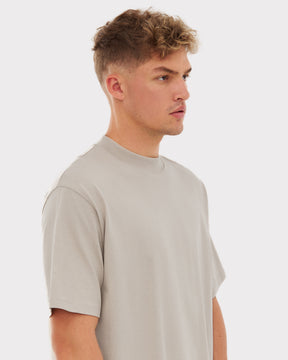 Mann mit kurzem lockigem Haar trägt beige T-Shirt 'Sammy' von Johnny Urban in moderner Passform