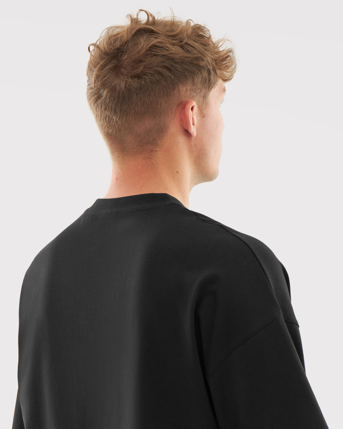 Mann von hinten mit kurzem braunem Haar trägt schwarzes T-Shirt 'Vic' von Johnny Urban