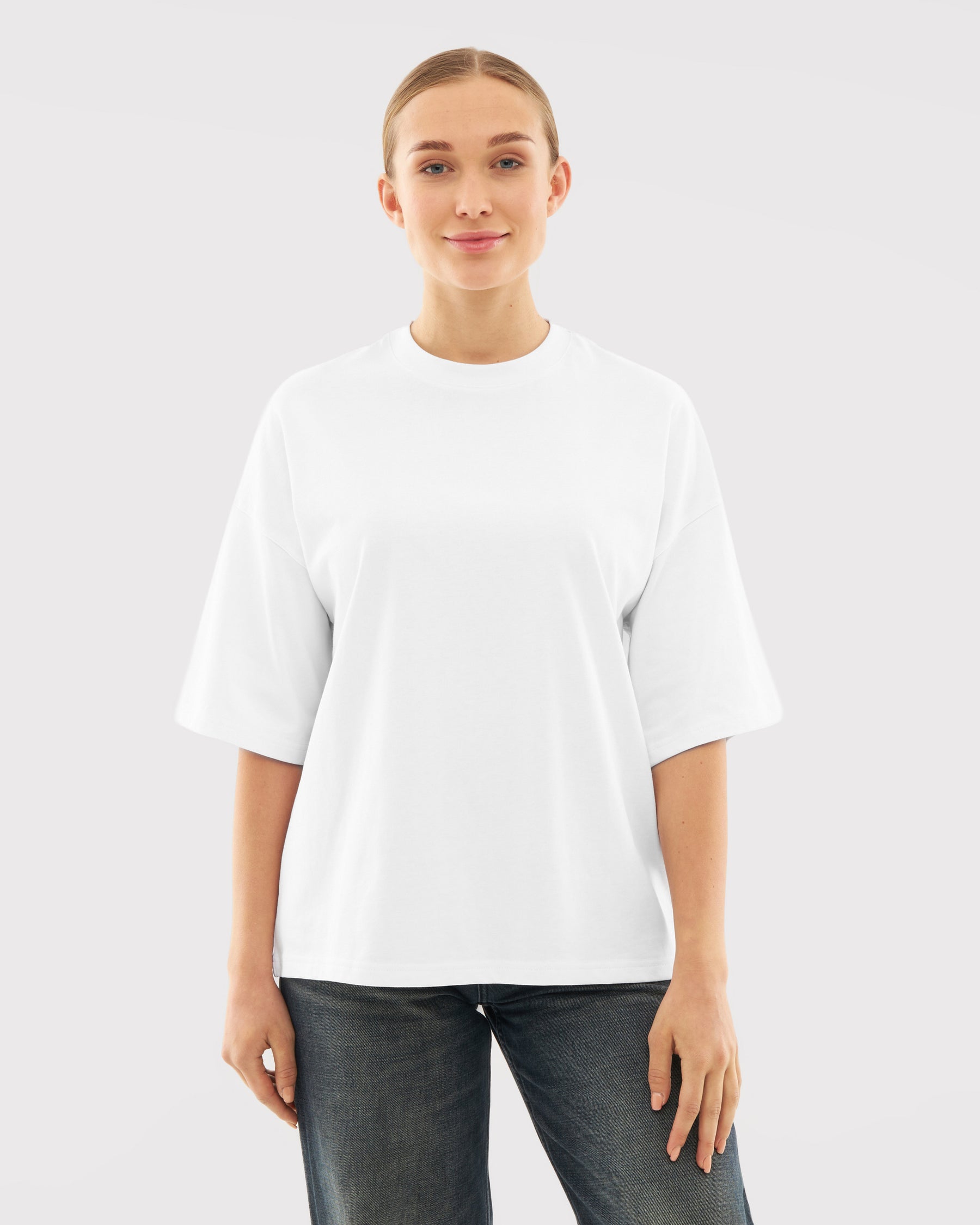 Frau trägt weißes T-Shirt 'Vic' mit halblangen Ärmeln und schwarze Jeans