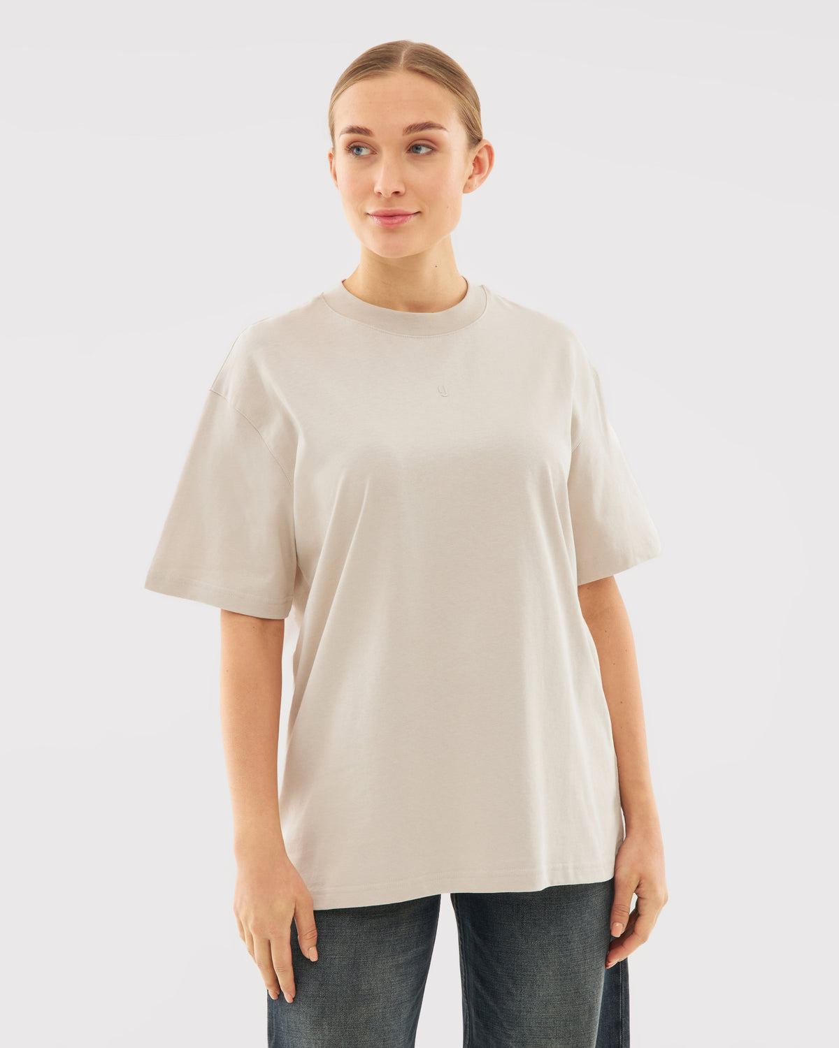 Beiges Oversize-T-Shirt 'Sammy Butterfly' an junger Frau mit dunkler Hose