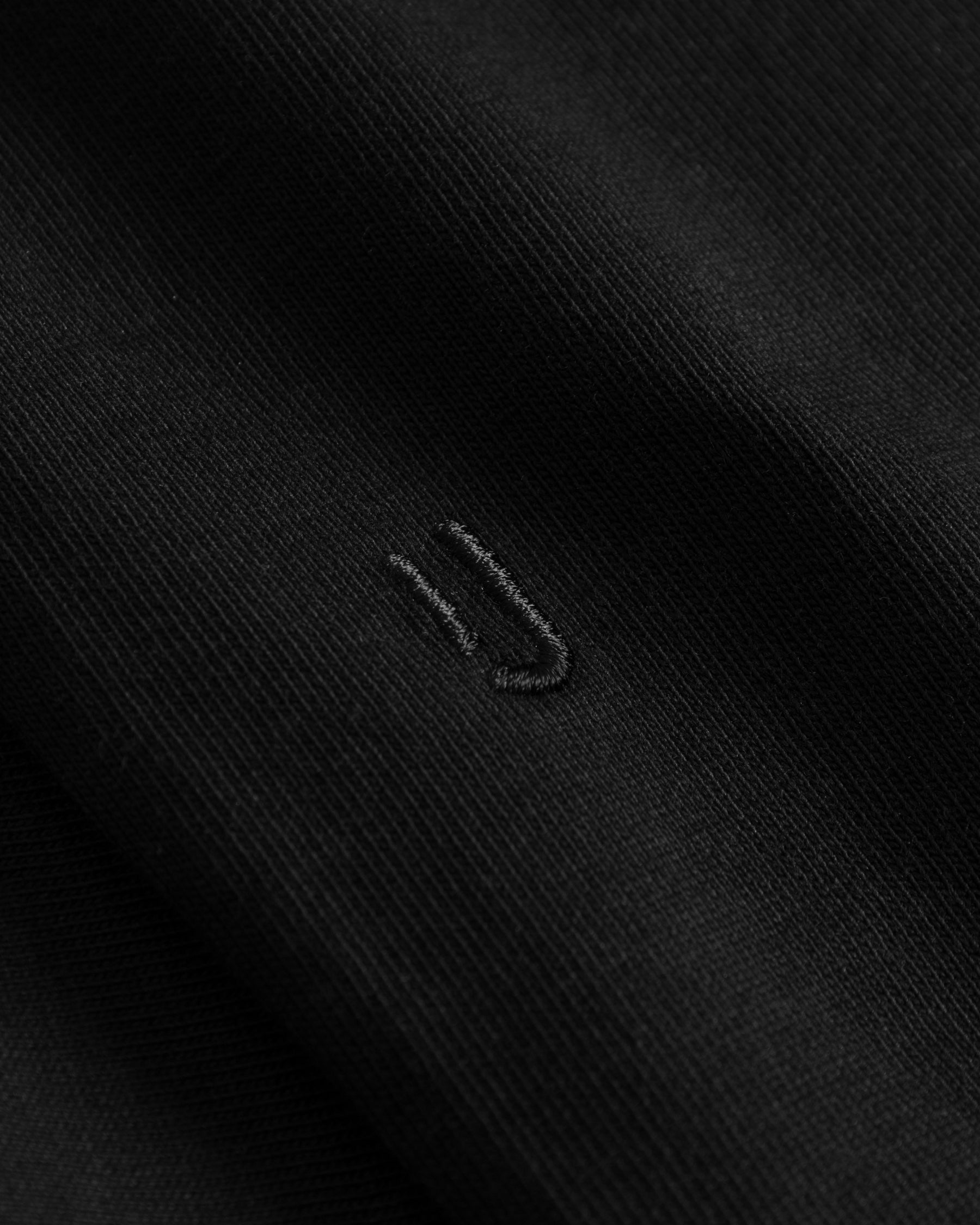 Schwarzer Oversize T-Shirt-Stoff mit dezentem, schwarzem Sticklogo