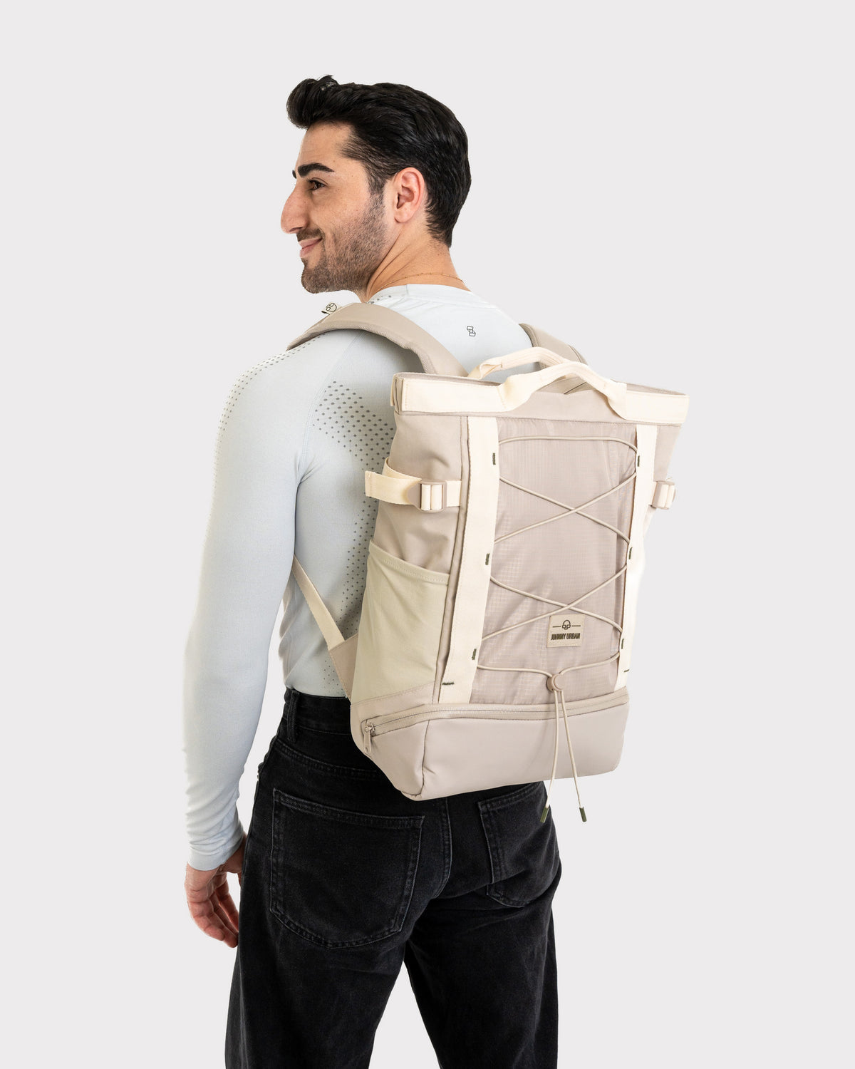 Mann trägt beigen Tagesrucksack Harper mit Kordelzug und Seitenfächern