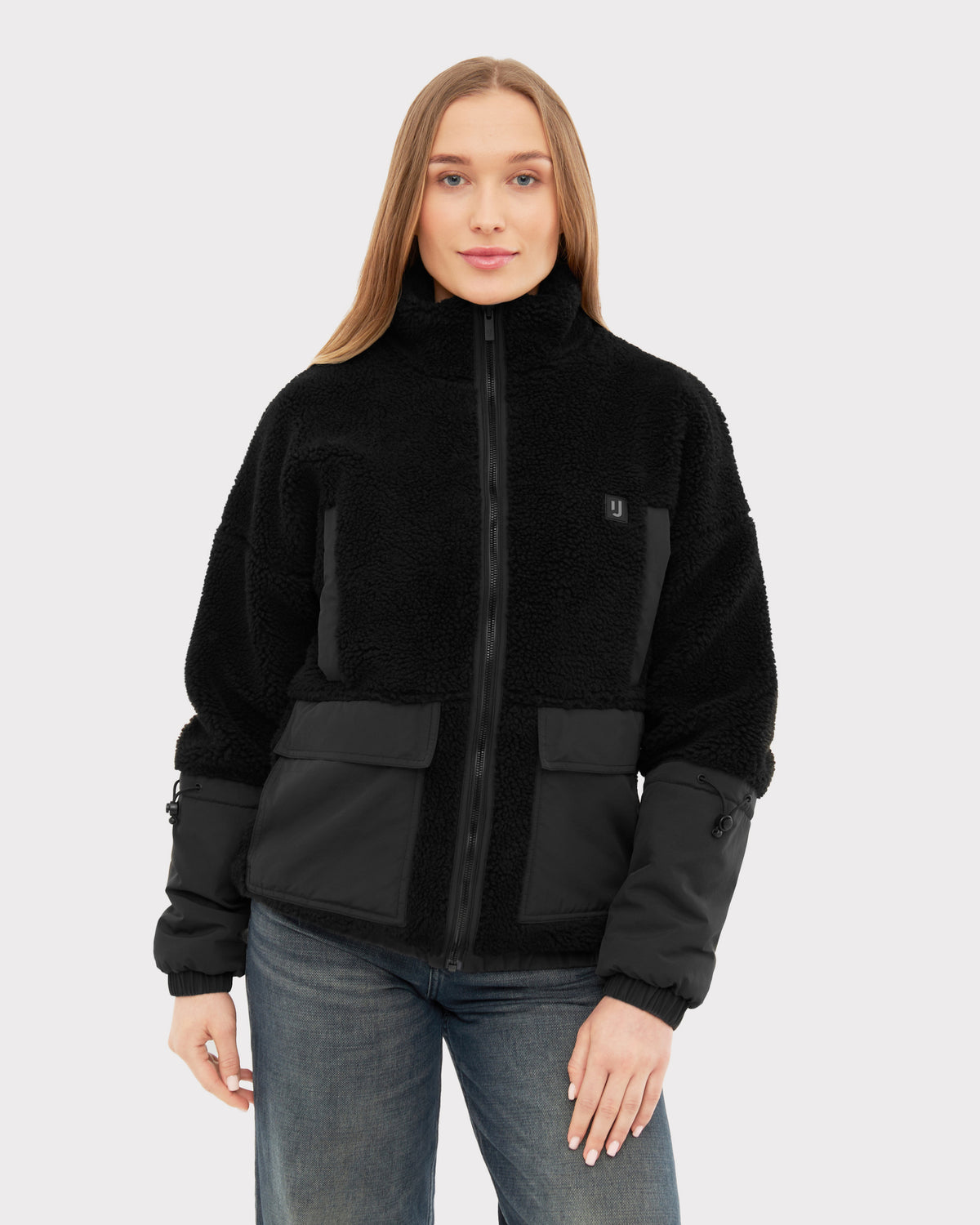 Damen trägt schwarze Teddy Fleecejacke 'Carson' mit Reißverschluss und zweifarbigen Stoffeinsätzen
