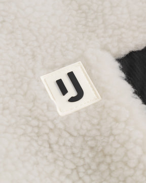 Nahe Aufnahme des weißen Teddy-Fleece-Stoffs der Fleecejacke "Carson" mit Johnny Urban Logo