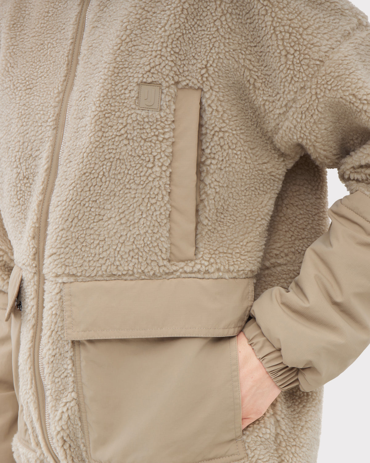 Beige Teddy Fleecejacke 'Carson' mit kuscheligem Obermaterial und glatten Ärmelabschnitten, eine Hand in der Tasche
