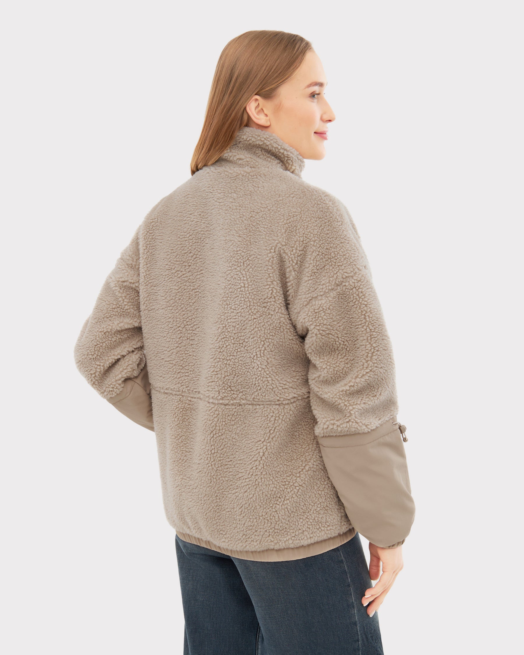 Frau trägt taupefarbene Teddy Fleecejacke "Carson" mit hohem Kragen und langen Ärmeln