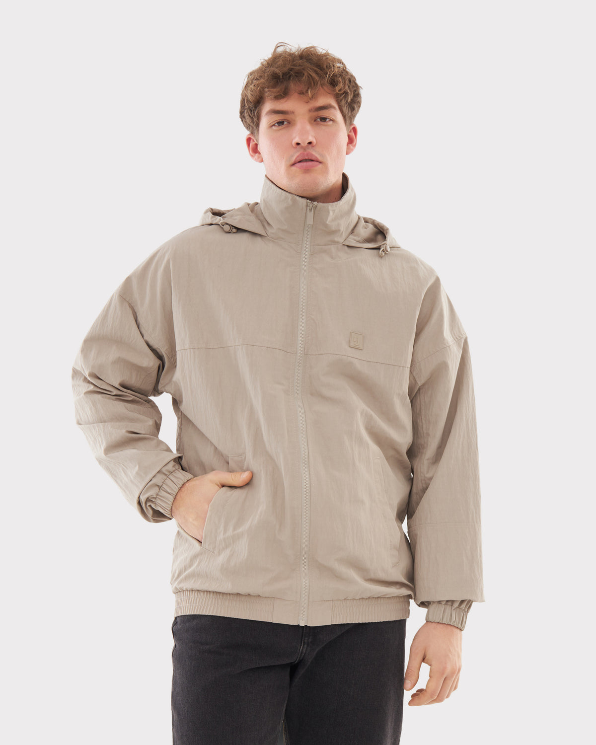 Mann trägt beige Übergangsjacke 'Lennon' mit Kapuze, langer Reißverschluss, elastischen Bündchen