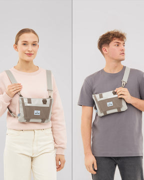 Beige Umhängetasche 'Avery' von Johnny Urban getragen von Frau in rosa Pullover und Mann in grauem T-Shirt