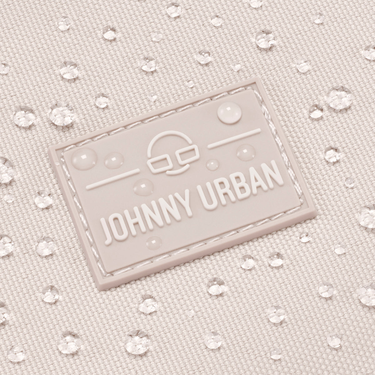 Wasserabweisendes Stoffmaterial der Umhängetasche 'Drew' in Sandfarbe mit JOHNNY URBAN Logo mit Wassertropfen darauf