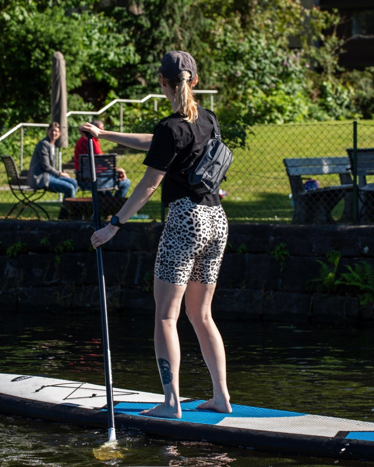 Frau auf Paddleboard mit schwarzer Lenkertasche Fahrrad 'Arlo' am Körper beim Paddeln