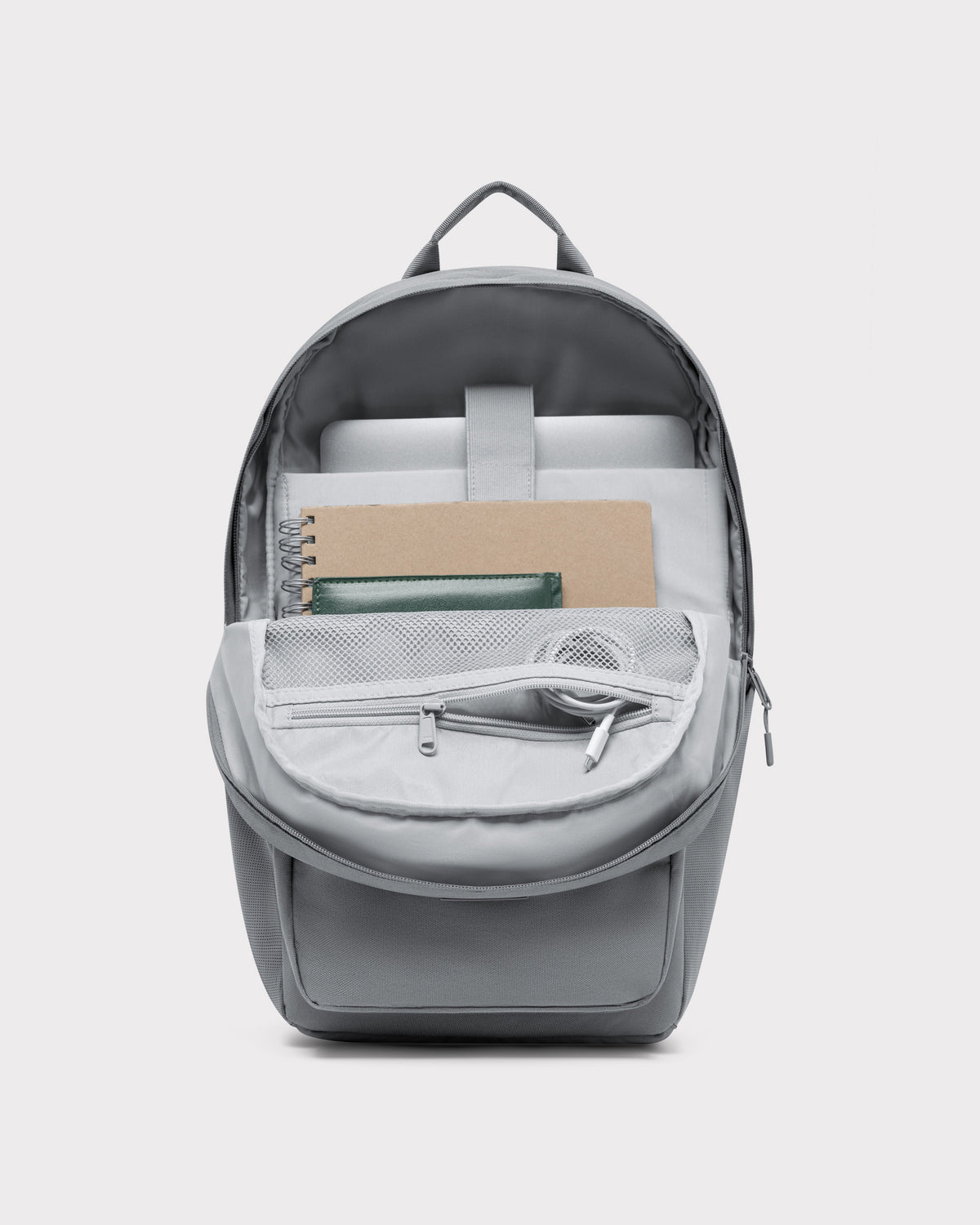 Dunkelgrauer Rucksack ‚Mo‘ mit offenem Hauptfach, Notebook, Spiralnotizbuch, grünem Geldbeutel und Kopfhörern