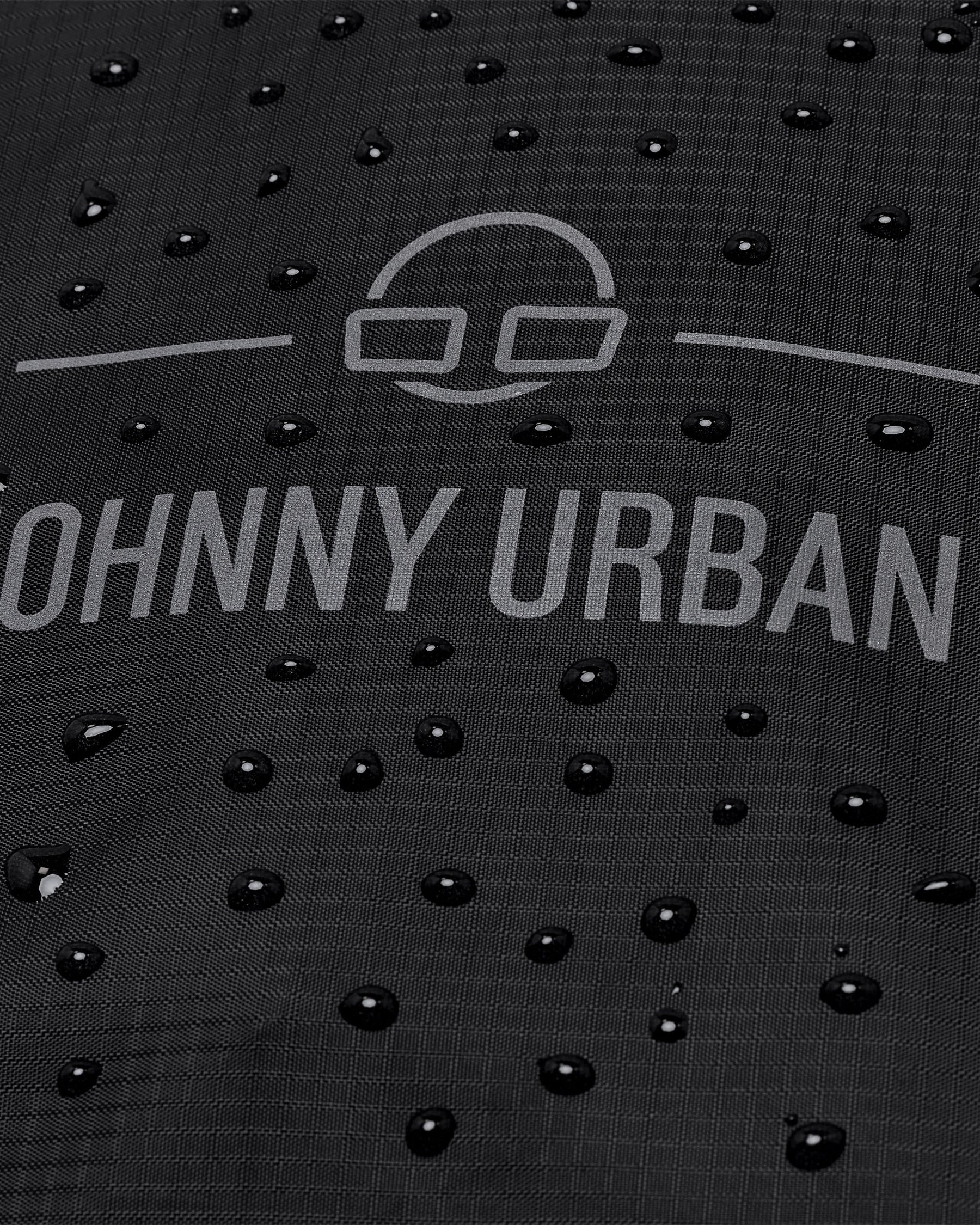 Wasserabweisende schwarze Regenschutzhülle 'Bo XL' von Johnny Urban mit Wassertropfen darauf
