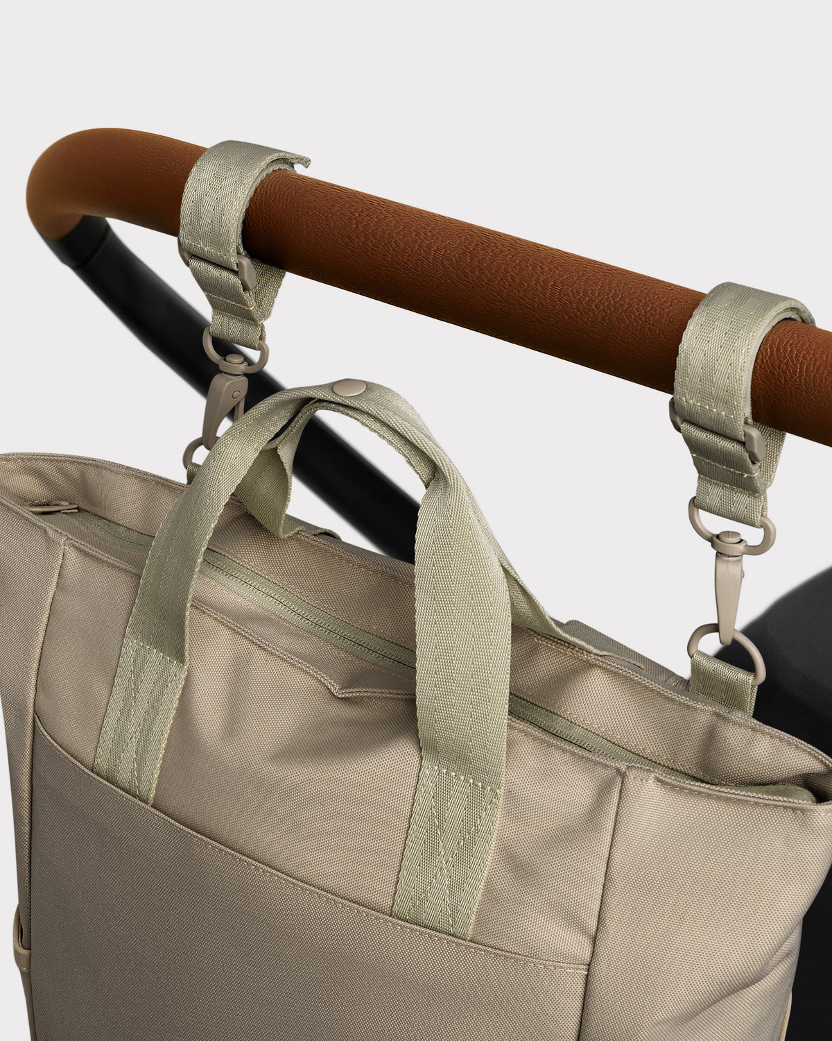 Beige Wickeltasche 'Blair' aus robustem Material, befestigt an Kinderwagen mit zwei Schlaufen