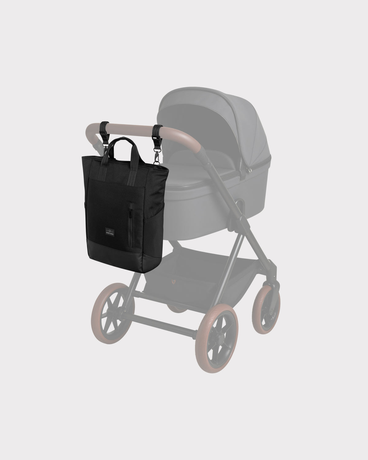 Schwarze Wickeltasche 'Blair' aus Stoff mit zwei Griffen, hängt an einem Kinderwagenlenker