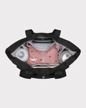 Schwarze Wickeltasche 'Blair' von oben mit rosa Babyjacke, Schnuller, Fläschchen und Thermoskanne im Inneren