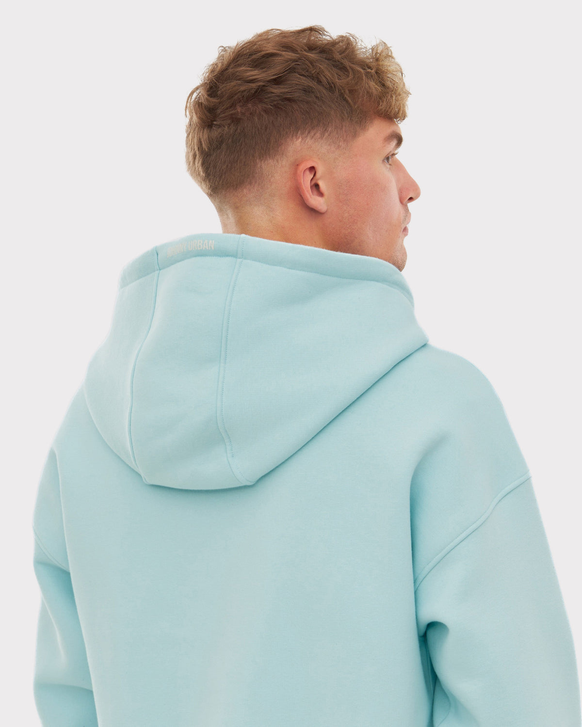 Rückenansicht eines Mannes in der Oversized Zip Hoodie 'Caleb' in hellblau mit Kapuze