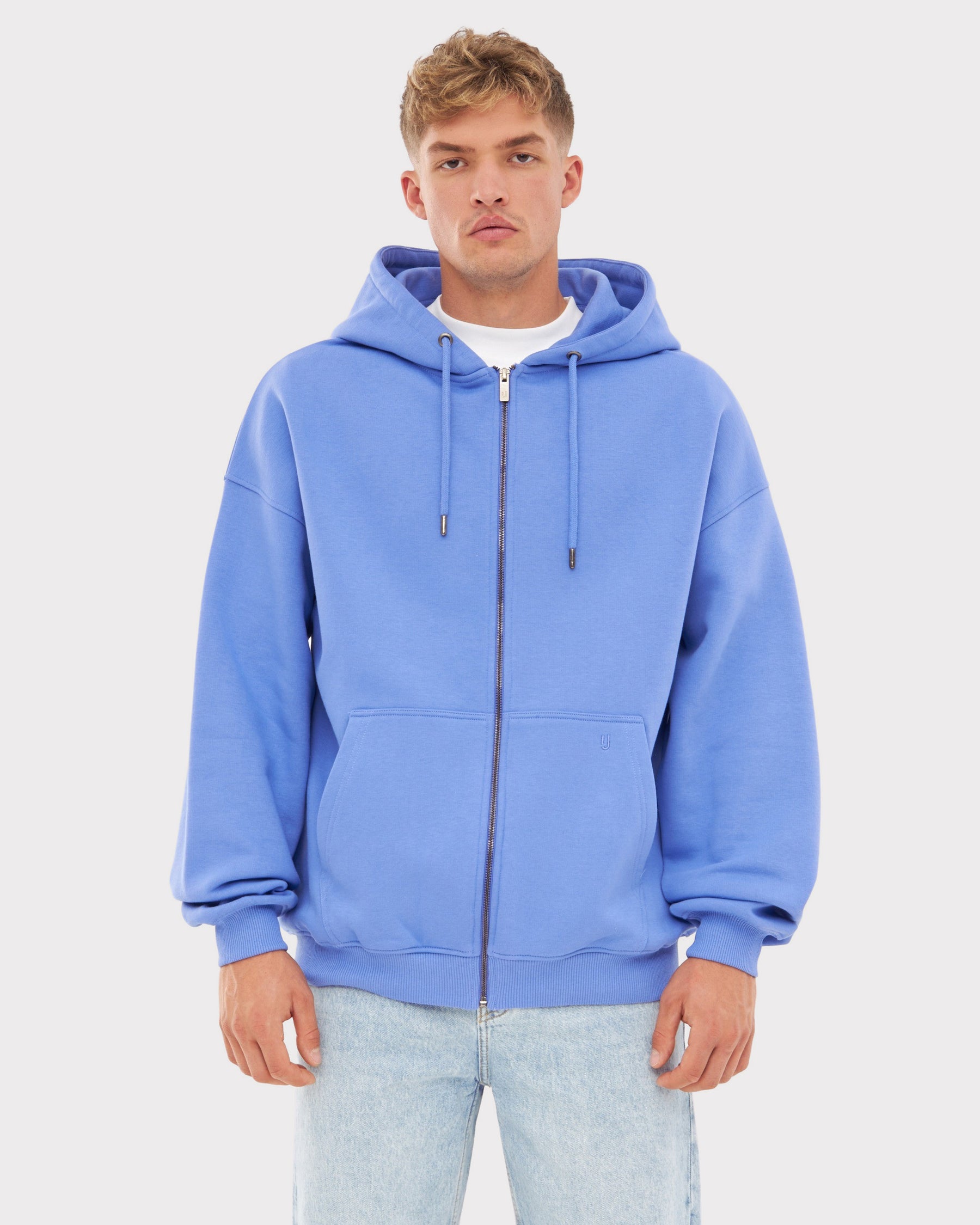 Mann trägt oversized Zip-Hoodie 'Caleb' in Blau-Lila mit Kapuze und Kängurutaschen