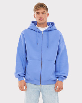 Mann trägt oversized Zip-Hoodie 'Caleb' in Blau-Lila mit Kapuze und Kängurutaschen