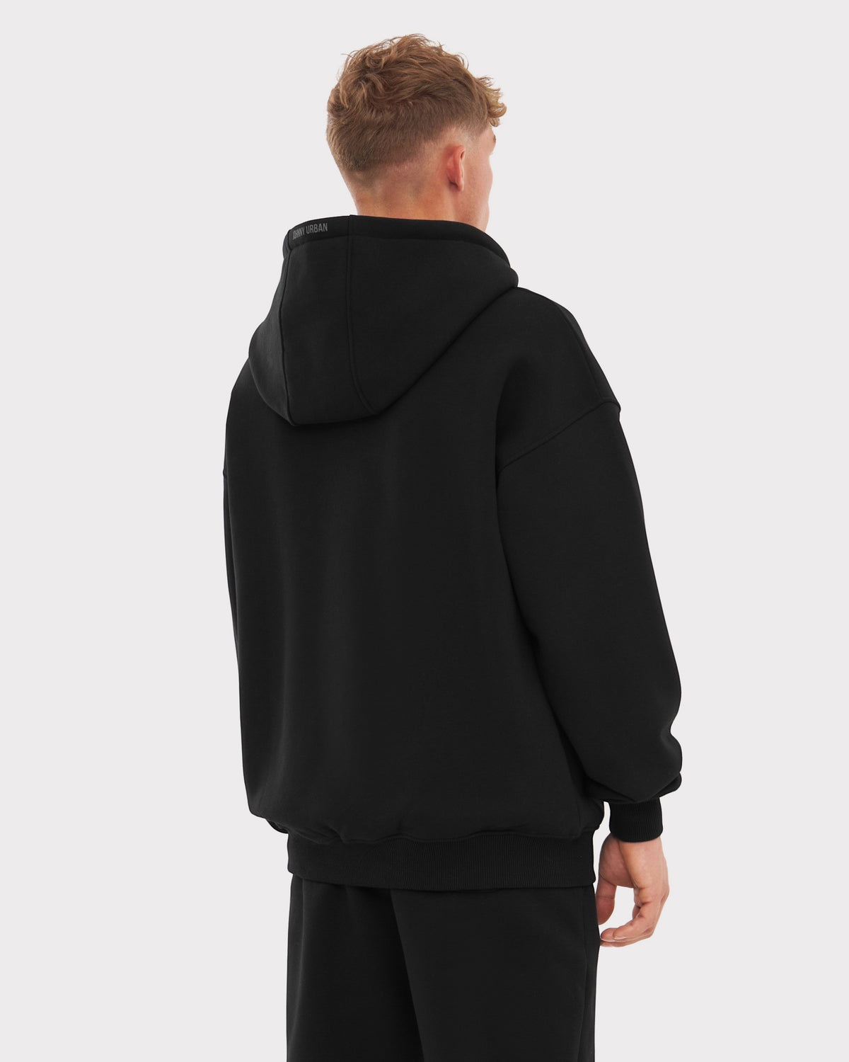 Mann trägt oversized Zip Hoodie 'Caleb' in schwarz, Rückansicht