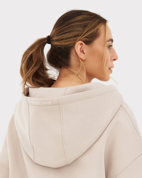 Rückansicht einer Frau mit beiger oversized Kapuzenjacke 'Caleb' von Johnny Urban, Pferdeschwanz