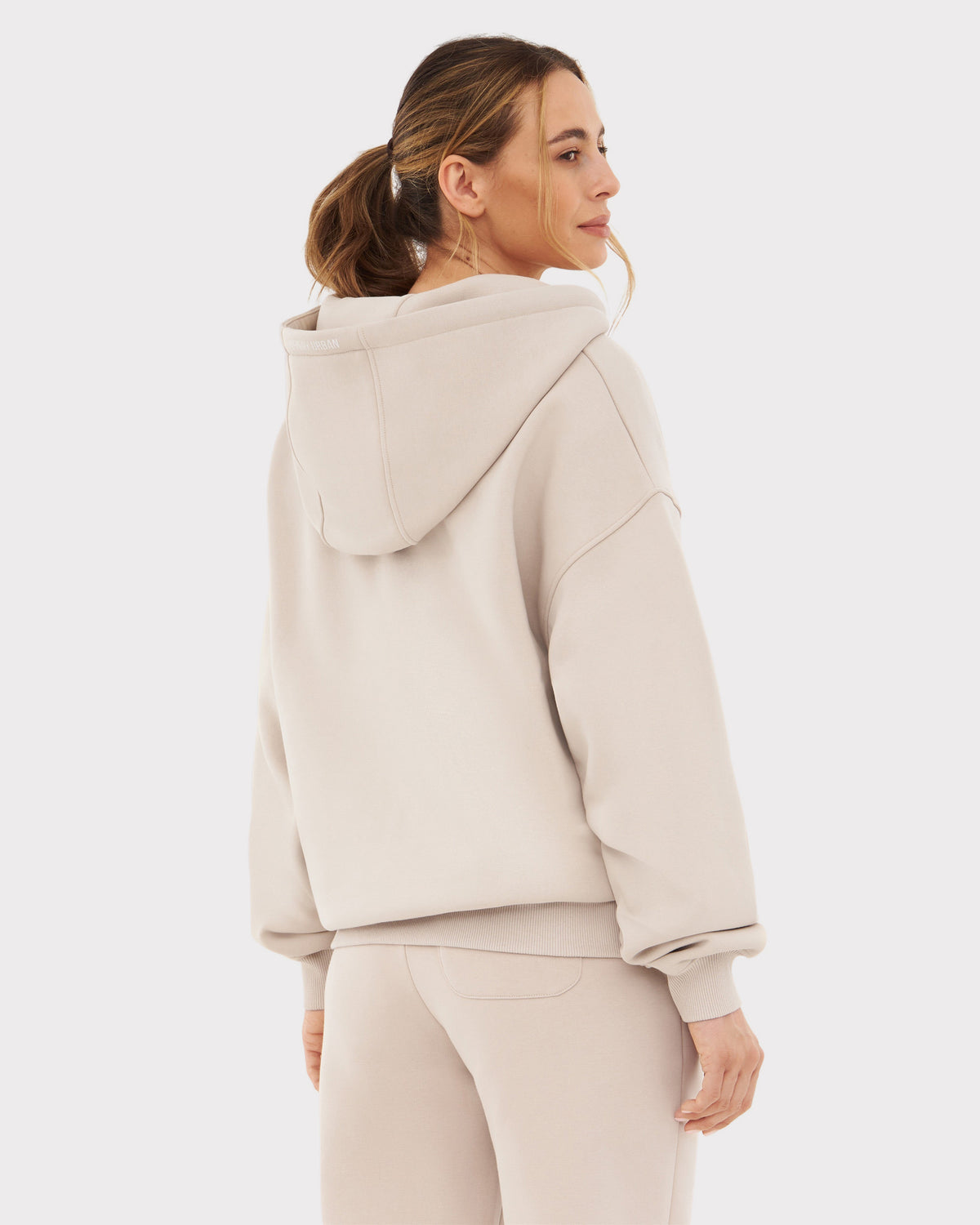 Frau trägt beigen Johnny Urban Oversized Zip Hoodie 'Caleb' von hinten mit Kapuze und Bündchen an Ärmeln und Saum