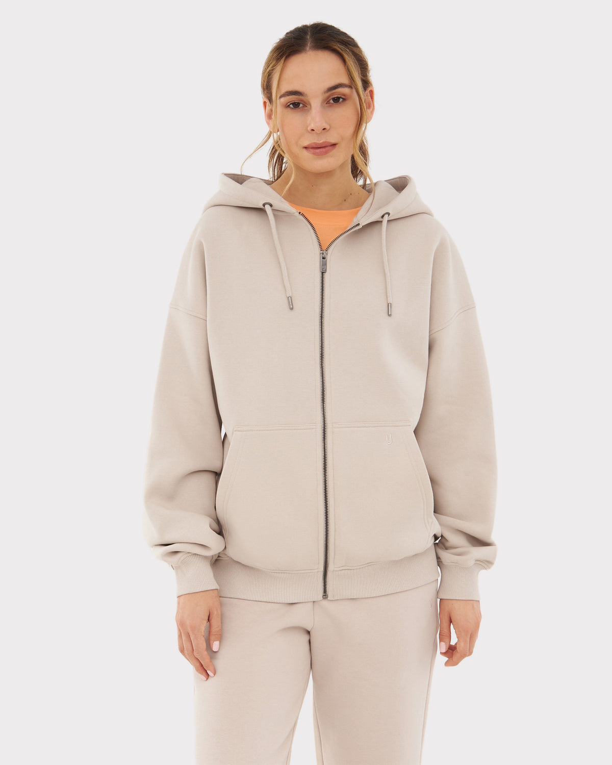 Frau trägt beige oversized Zip Hoodie 'Caleb' und passende Hose, Kapuze mit Kordeln