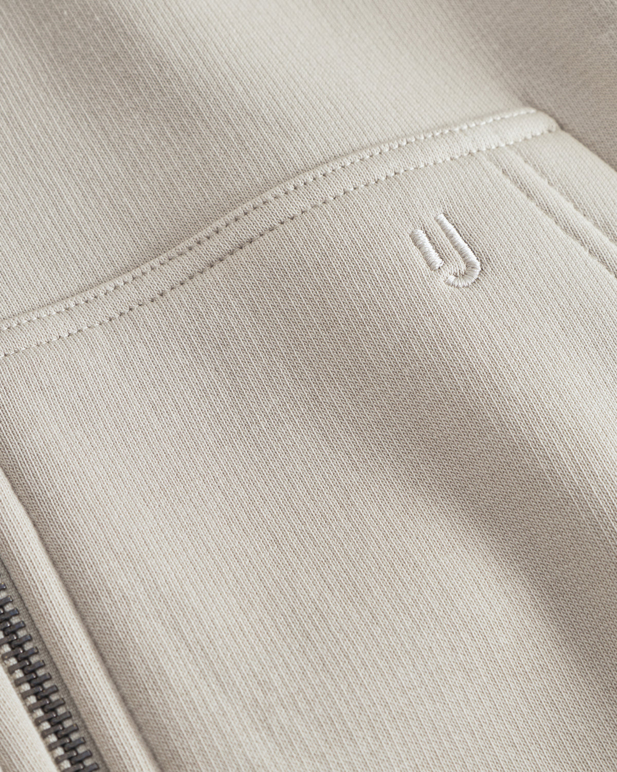 Beiger Oversized Zip Hoodie 'Caleb' mit aufgesticktem 'JU'-Logo an der Vorderseite und Metallreißverschluss