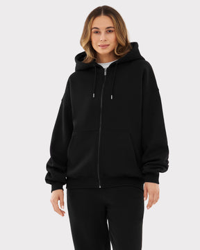 Frau trägt oversized Zip-Hoodie 'Caleb' in Schwarz mit Kapuze und Kängurutasche