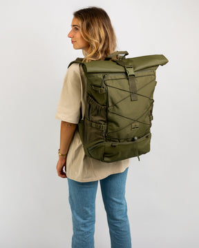 Frau trägt olivgrünen Johnny Urban Reiserucksack 'Allen Large Travel' mit Rollverschluss und elastischem Frontband