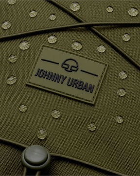 Nahaufnahme des wasserabweisenden Materials des olivgrünen Johnny Urban Reiserucksacks 'Allen Large Travel' mit Wassertropfen darauf