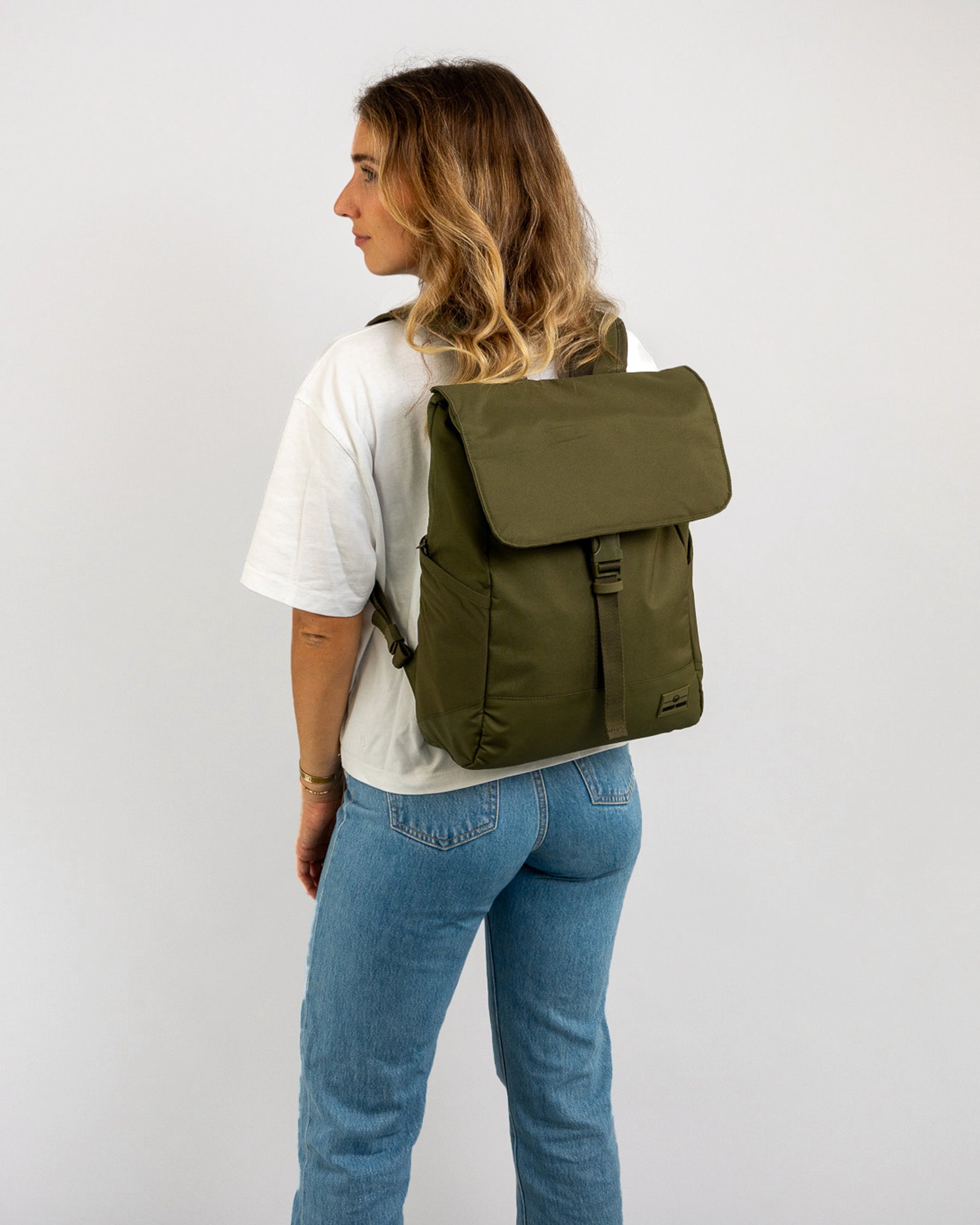 Frau mit olivgrünem Johnny Urban Rucksack 'Mika', trägt weiße T-Shirt und blaue Jeans