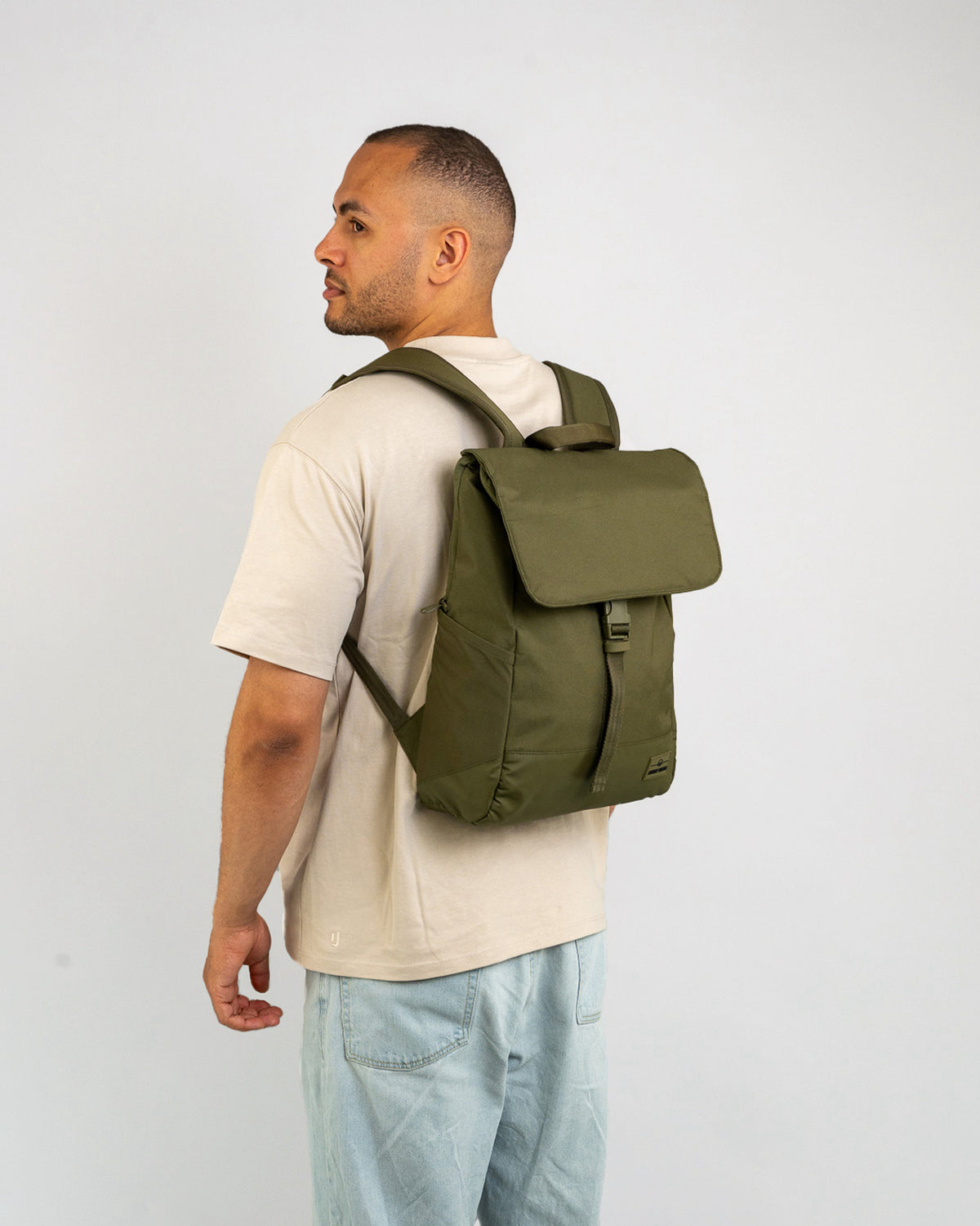 Mann trägt olivgrünen Johnny Urban Rucksack 'Mika' mit Klappe und Verschluss auf dem Rücken