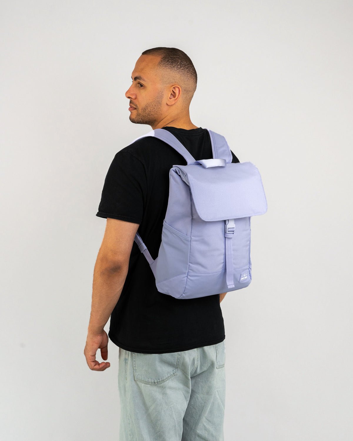 Mann trägt lila Johnny Urban Rucksack 'Mika' mit Klappe und Schnalle