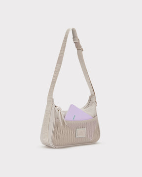 Beige Handtasche 'Maddy' mit Netzvortasche und verstellbarem Schulterriemen, lila Notizbuch steckt in der Tasche