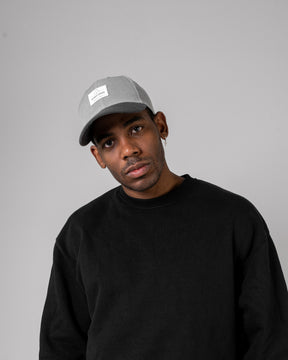 Mann in schwarzem Pullover trägt graue, gewölbte 'Dean' Cap von Johnny Urban