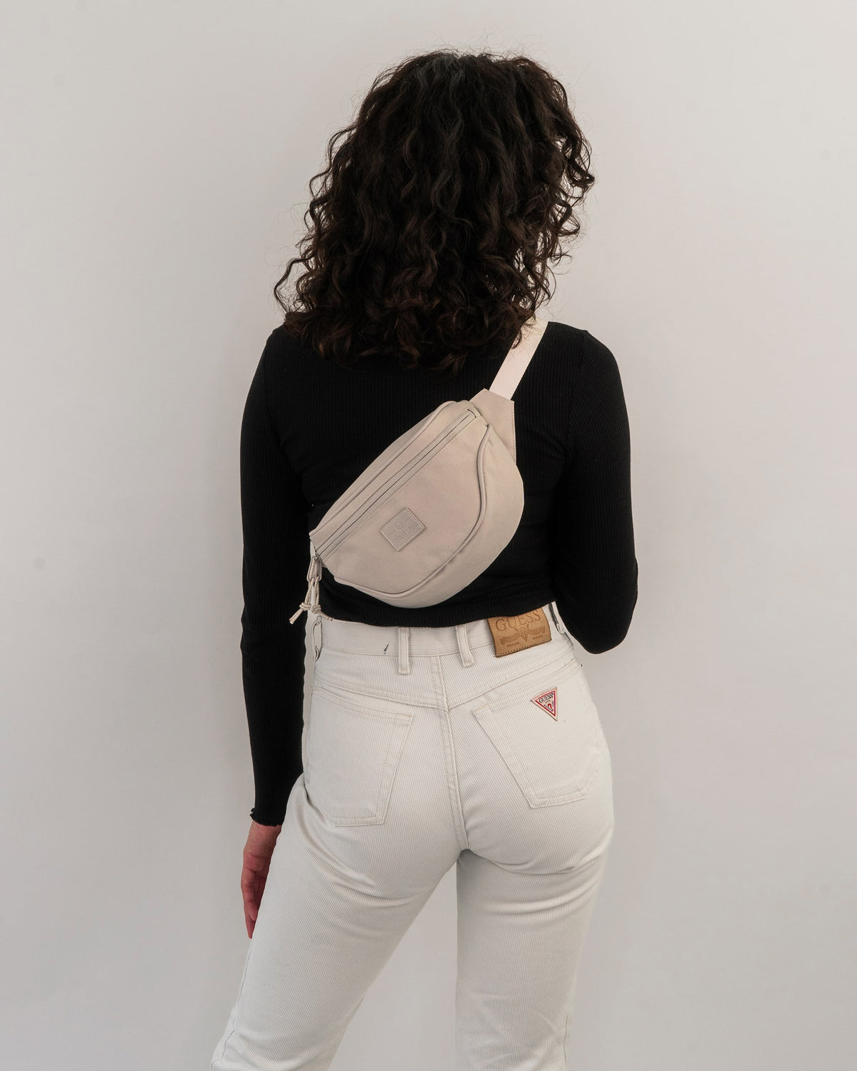 Frau von hinten mit beige-farbener Bauchtasche 'Ben' von Johnny Urban quer über dem Rücken