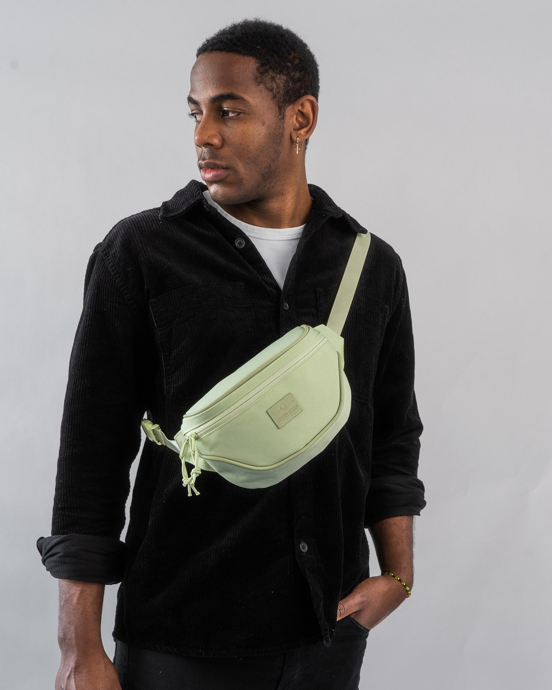 Mann trägt limegrüne Bauchtasche 'Ben' quer über der Brust, schwarze Jacke und weißes T-Shirt