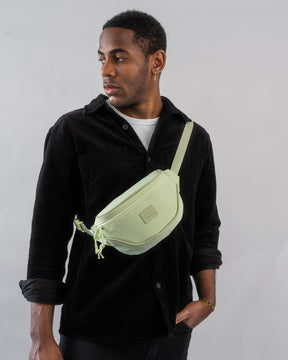 Mann trägt limegrüne Bauchtasche 'Ben' quer über der Brust, schwarze Jacke und weißes T-Shirt