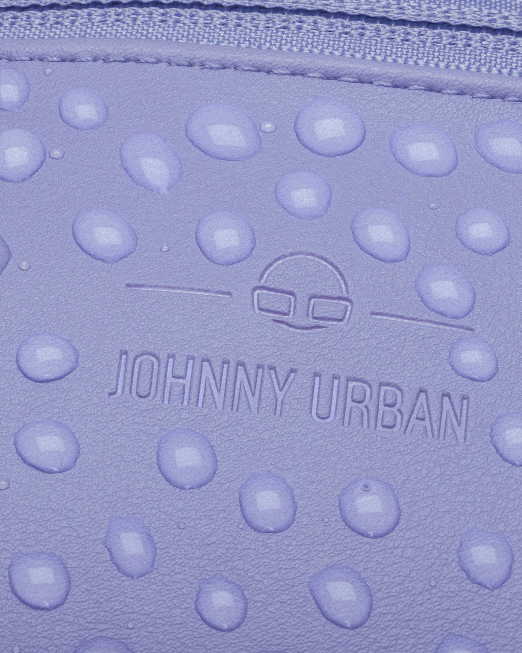 Nahe Ansicht der wasserabweisenden lila Kunstlederoberfläche der Bauchtasche 'Toni' mit Johnny Urban Logo
