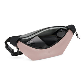 Große Bauchtasche 'Riley' von Johnny Urban in Rosa mit schwarzem Gurt, geöffnet mit sichtbarem Handy, Geldbörse und Sonnenbrille