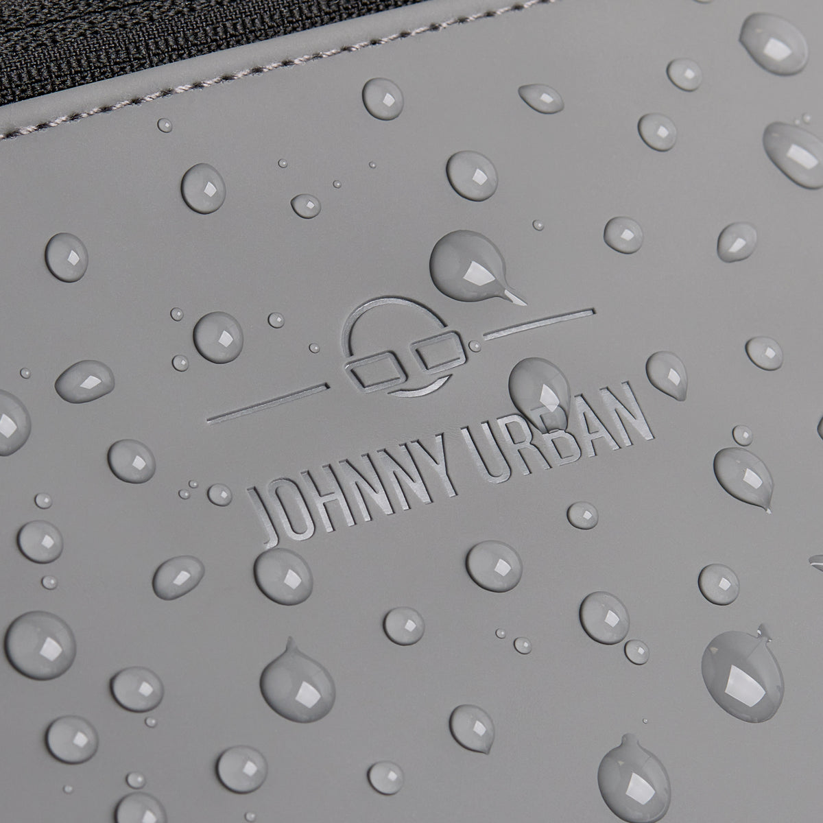 Wasserabweisende graue Oberfläche der Bauchtasche 'Riley' mit eingeprägtem Johnny Urban Logo