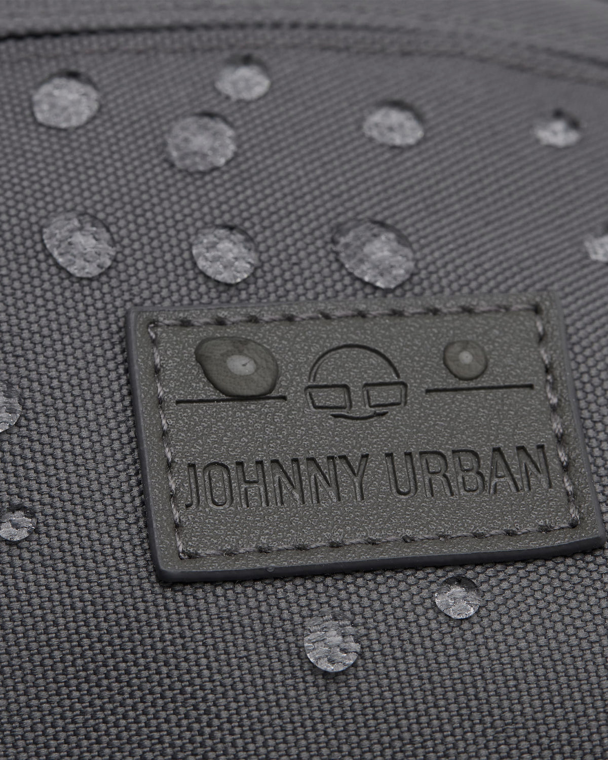 Wasserdichte graue Bauchtasche 'Tom' mit Johnny Urban Logo und sichtbaren Wassertropfen auf der Oberfläche