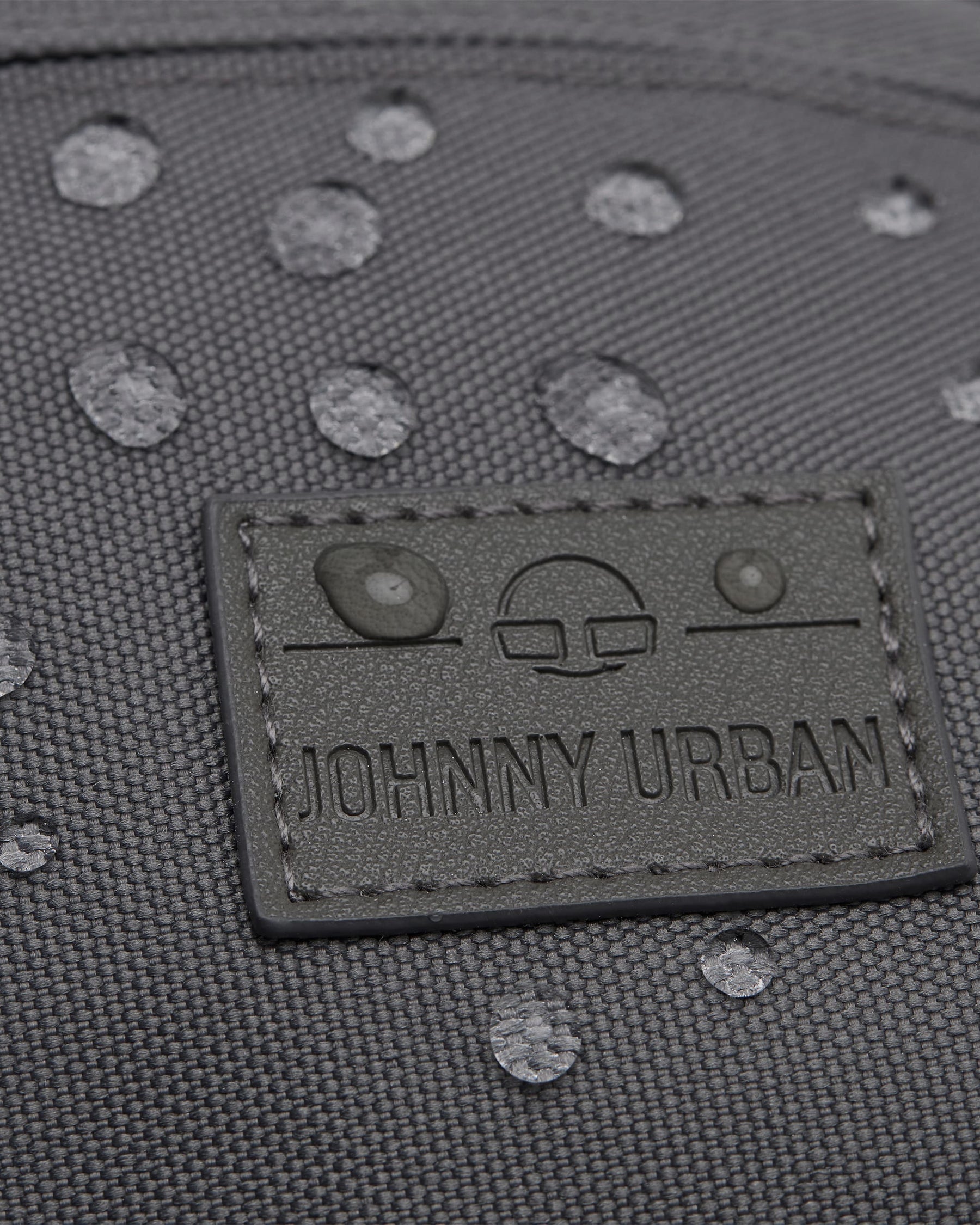Wasserdichte graue Bauchtasche 'Tom' mit Johnny Urban Logo und sichtbaren Wassertropfen auf der Oberfläche