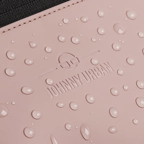 Nahaufnahme der rosa-grauen, wasserdichten Bauchtasche ‚Riley‘ von Johnny Urban mit Wassertropfen auf der Oberfläche