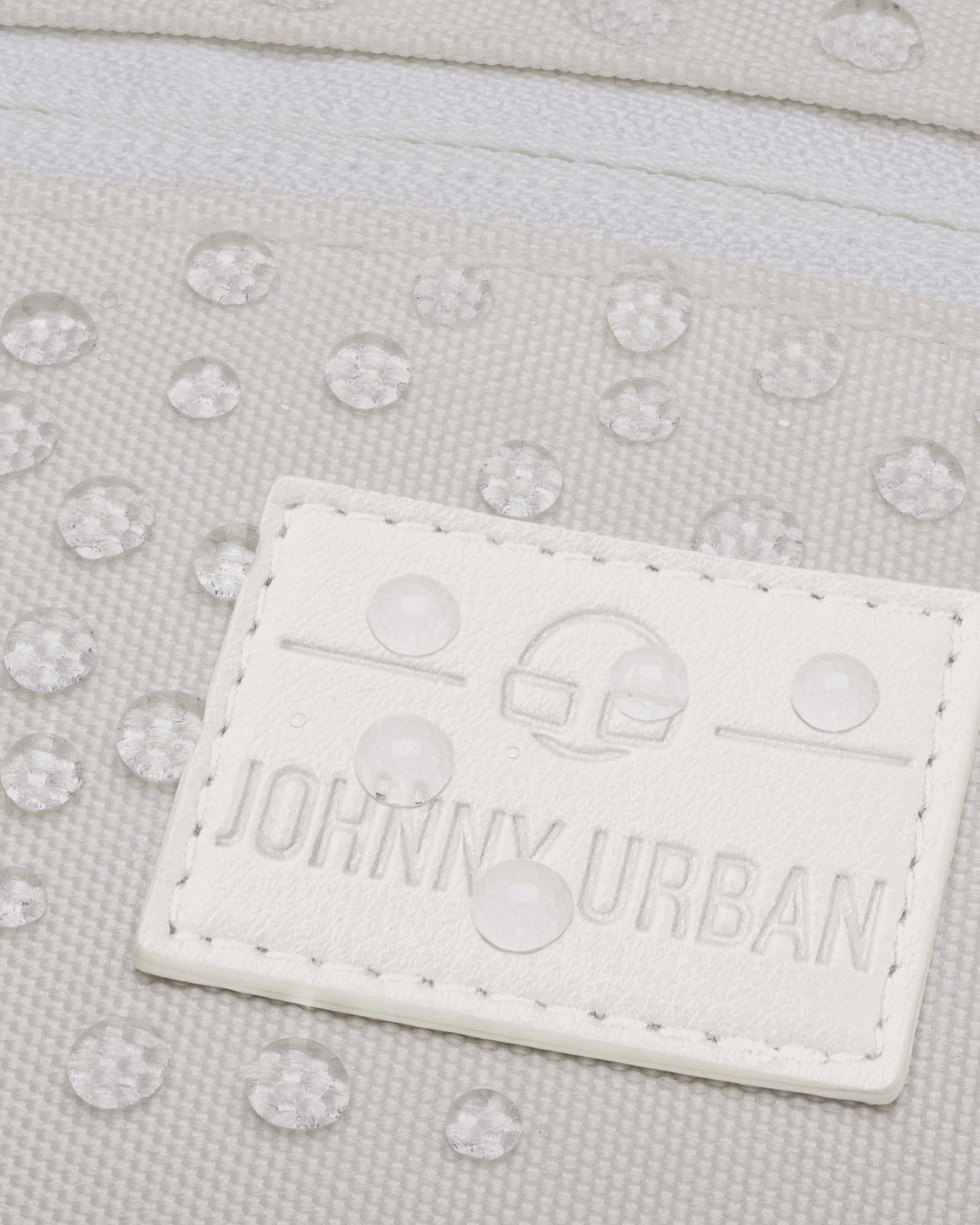 Nahaufnahme der weißen, wasserabweisenden Bauchtasche 'Ben' mit JOHNNY URBAN Logo und Wassertröpfchen