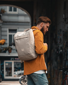 Mann trägt beigen Businessrucksack 'Jasper' von Johnny Urban, urbaner Hintergrund mit Graffiti