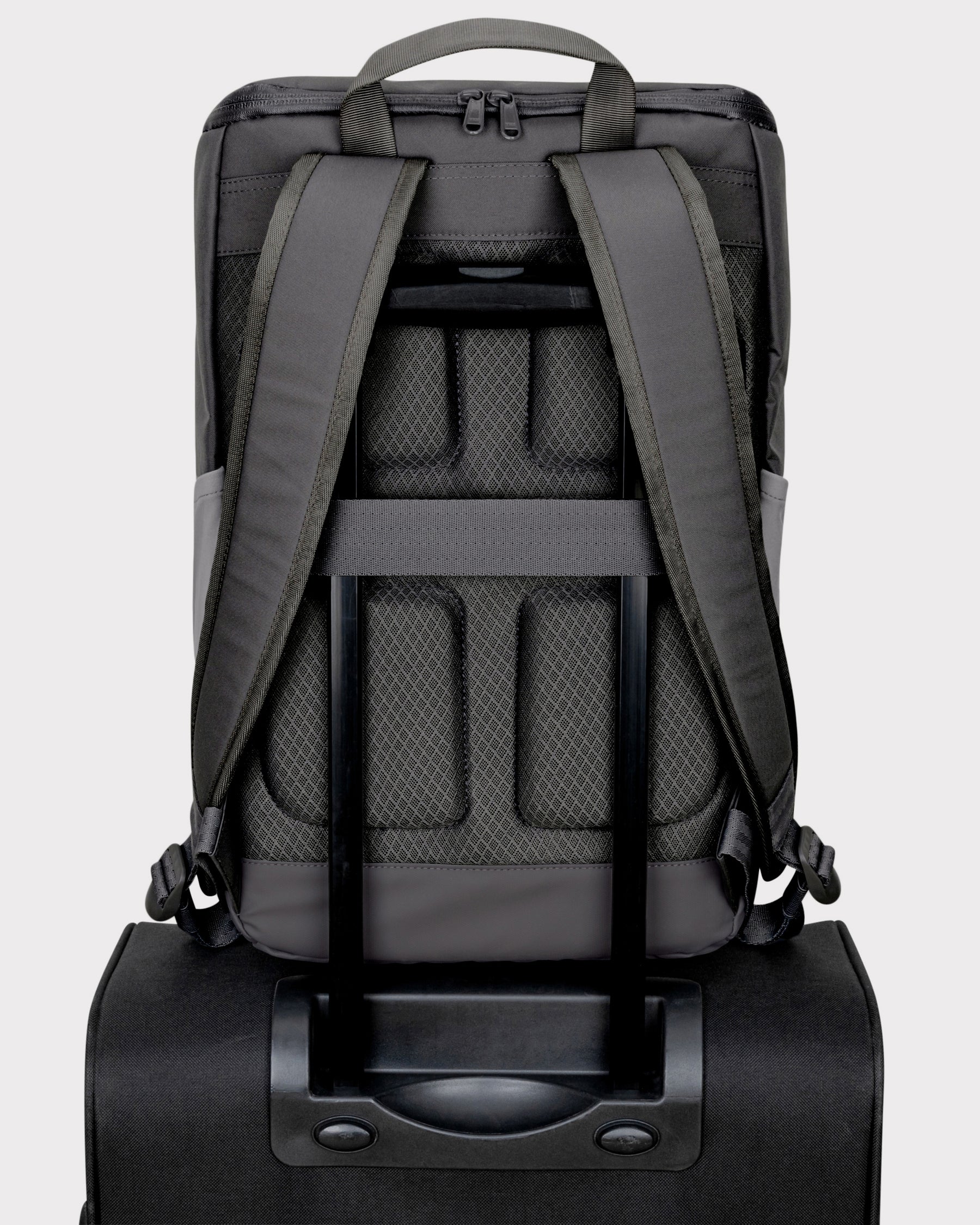 Rückansicht des grauen Business-Rucksacks Jasper mit gepolsterten Trägern, gepolstertem Rücken und Befestigungsschlaufe über dem Griff eines Trolleys