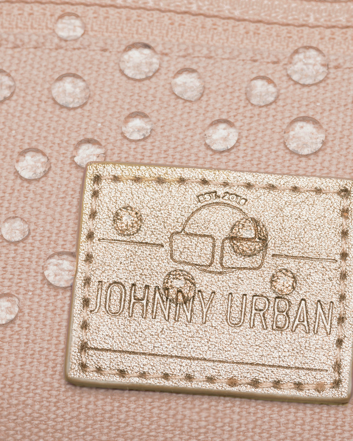 Nahaufnahme des wasserabweisenden Canvas-Gewebes und des aufgenähten JOHNNY URBAN Lederlabels der rosa Bauchtasche 'Toni'